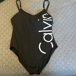 Calvin Klein, one piece swimsuit, black with insignia down the left side.
